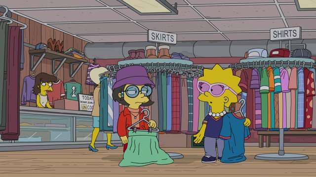 L'intérieur de la friperie et ses portants de vêtements.
